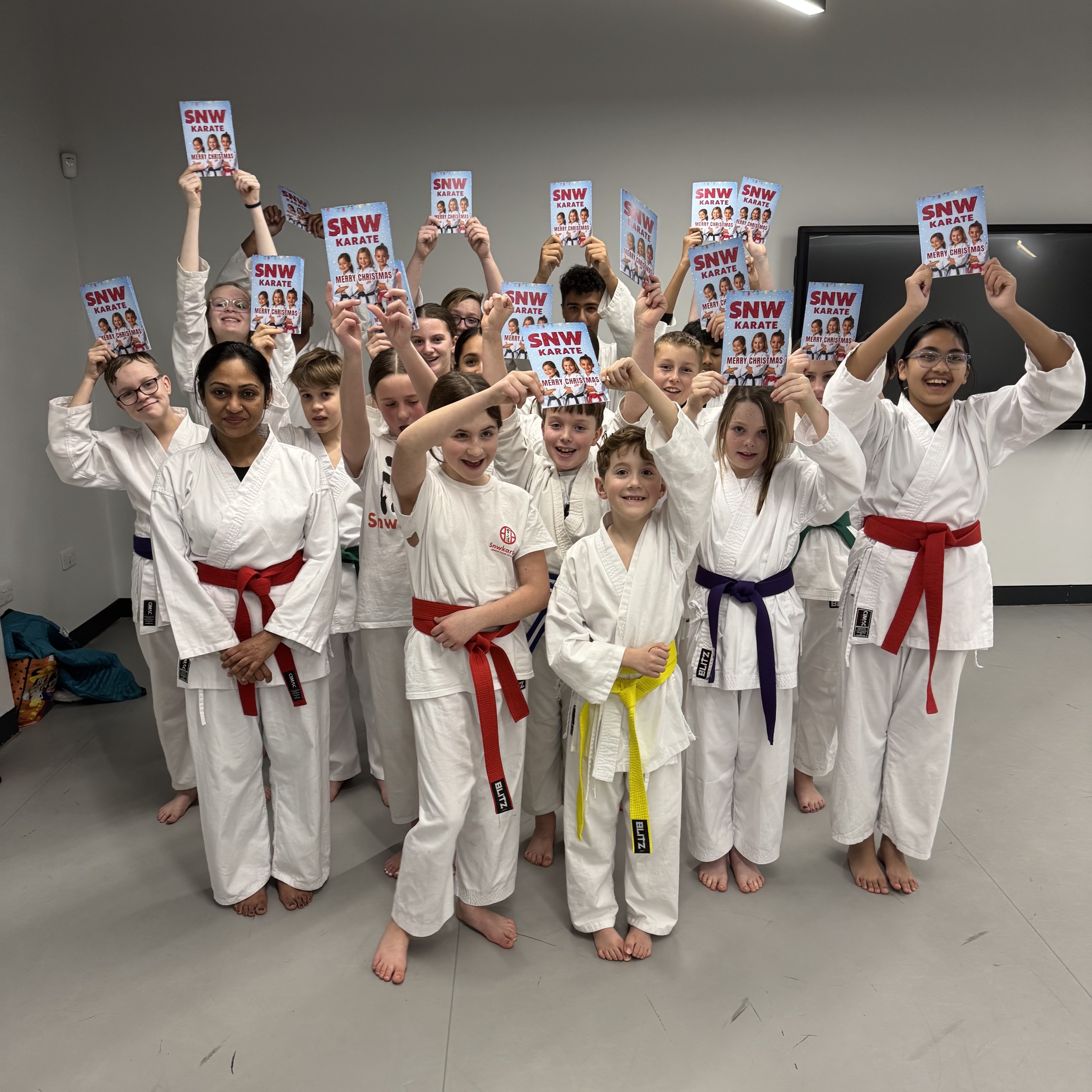 Martial arts students at SNW Karate Chester holding SNW Karate Christmas cards
